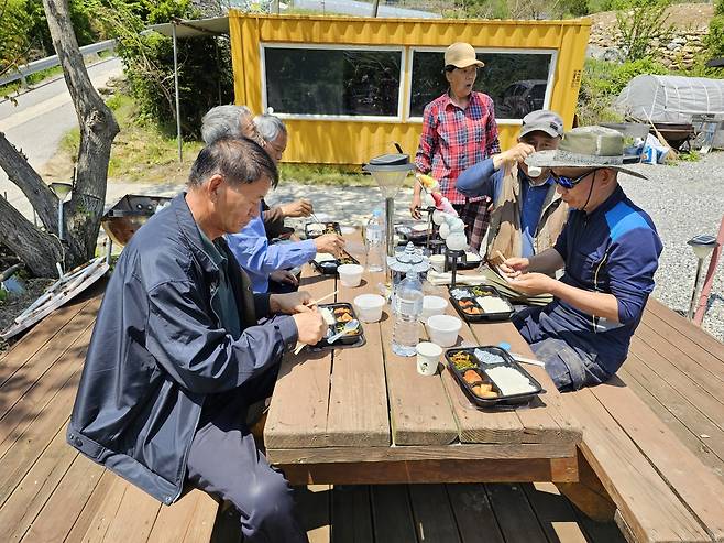 지난해 6월 강원 정선군 정선읍 용탄 3리 주민들이 농번기 마을 공동급식용으로 배달된 도시락을 먹고 있다. 정선군 제공