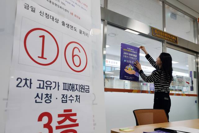 지난 14일 충남 공주시 옥룡동 행정복지센터에서 한 직원이 신청자들을 위한 안내문을 붙이고 있다. 연합뉴스