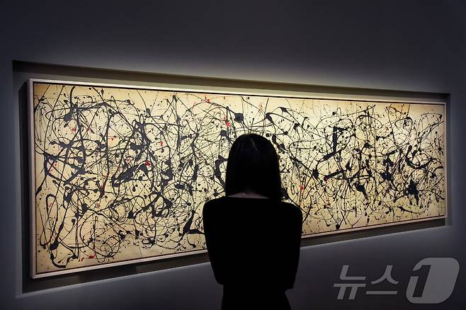 지난 8일(현지시간) 미국 뉴욕 크리스티에서 진행된 '20·21세기 미술 봄 경매' 프리뷰에서 한 관람객이 잭슨 폴록의 '넘버 7A, 1948'을 바라보고 있다. 2026.05.09 ⓒ 로이터=뉴스1