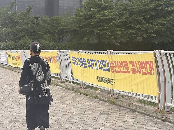 19일 오후 찾은 대전 유성구 학하동 행정복지센터 인근 다리 위에 내걸린 '송전선로 반대' 현수막 옆으로 한 시민이 지나가고 있다. 최다인 기자