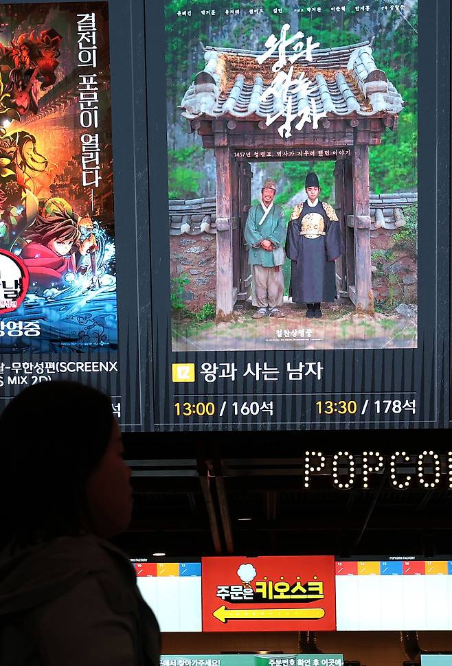 지난 3월 25일 서울 용산구의 한 영화관에서 한 관람객이 영화 '왕과 사는 남자' 포스터 옆을 지나가고 있다. 뉴스1