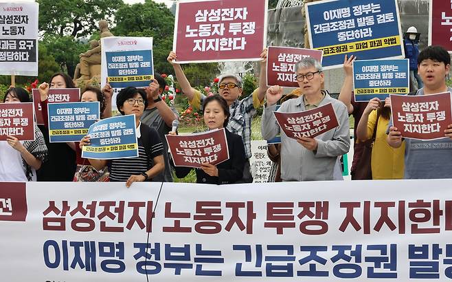 19일 서울 청와대 앞에서 삼성전자 노동자 투쟁을 지지하는 노동단체 관계자들이 기자회견을 열고 정부의 긴급조정권 발동 검토 중단을 촉구하는 구호를 외치고 있다. 연합뉴스