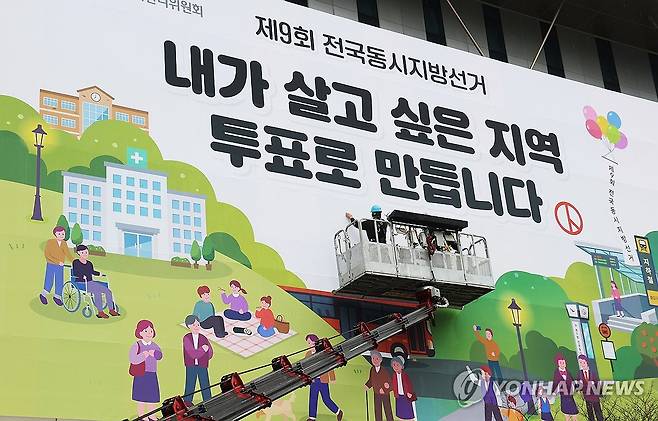 '내가 살고 싶은 지역 투표로 만듭니다' (수원=연합뉴스) 홍기원 기자 = 제9회 전국동시지방선거를 55일 앞둔 9일 경기도 수원시 영통구 경기도선거관리위원회에서 관계자들이 투표 참여 홍보 현수막을 설치하고 있다. 2026.4.9 xanadu@yna.co.kr
