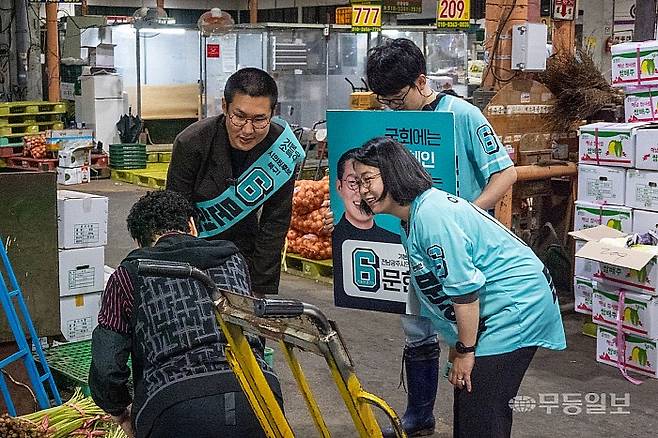 문현철 기본소득당 전남광주통합시의원 후보가 21일 오전 용혜인 대표와 함께 광주 북구 각화동 농산물도매시장에서 상인들과 인사하고 있다. 기본소득당 제공