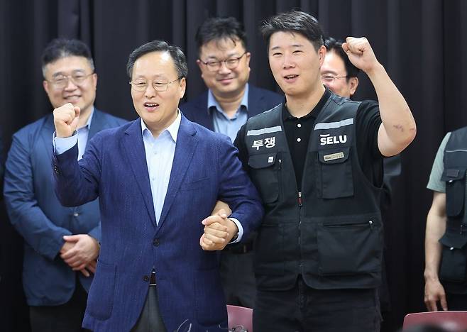 20일 경기도 수원 장안구 경기고용노동청에서 열린 삼성전자 임금협상을 마친 후 여명구 삼성전자 DS 부문 피플팀장과 최승호 삼성그룹 초기업노동조합 삼성전자지부 위원장이 잠정 합의안에 서명한 후 파이팅을 외치고 있다. 연합뉴스