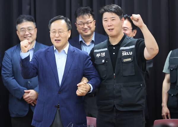 ▲2026년 5월20일 경기도 수원시 장안구 경기고용노동청에서 열린 삼성전자 임금협상을 마친 후 여명구 삼성전자 DS(디바이스솔루션·반도체 사업 담당) 피플팀장과 최승호 삼성그룹 초기업노동조합 삼성전자지부 위원장이 잠정 합의안에 서명한 후 파이팅을 외치고 있다. ⓒ 연합뉴스