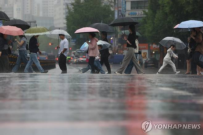 세차게 내리는 비 (서울=연합뉴스) 이진욱 기자 = 20일 서울 광화문광장 부근에서 시민들이 우산을 쓰고 이동하고 있다. 2026.5.20 cityboy@yna.co.kr