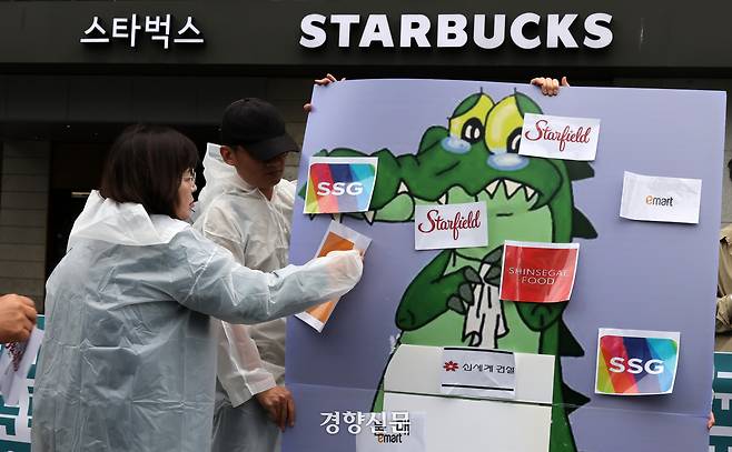 지난 21일 서울 종로구 스타벅스 광화문점 앞에서 5공피해자단체연합회, 국가폭력피해범국민연대, 박종철기념사업회 등 국가폭력 피해자 단체 주최로 열린 기자회견에서 참석자들이 스타벅스 코리아의 5·18 민주화운동기념일 ‘탱크 데이’ 프로모션을 규탄하며 신세계 계열 상품 불매 상징의식에 참여하고 있다. 김정근기자
