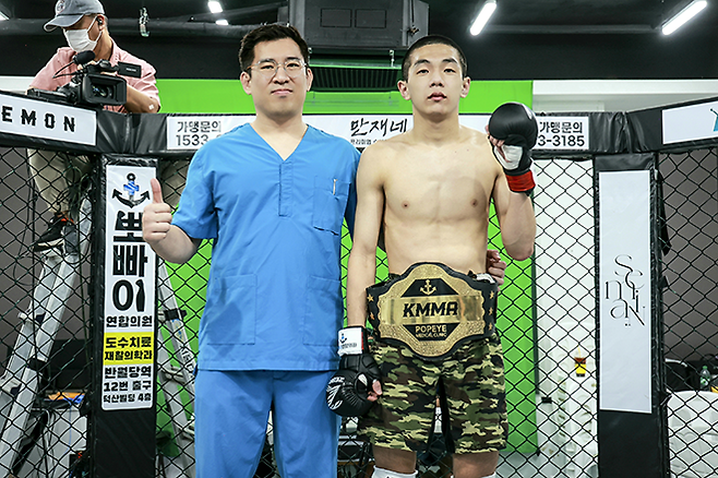 KMMA 플라이급 챔피언 문순수가 대회 메인스폰서 겸 소속 에이전시 대표 김성배 뽀빠이연합의원 원장과 기념 촬영을 하고 있다. 사진=뽀빠이연합의원 KMMA 파이터 에이전시 제공