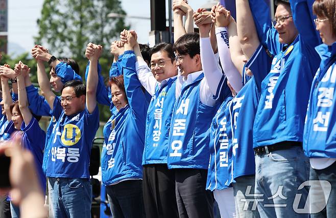 정원오 더불어민주당 서울시장 후보가 22일 오후 서울 노원구 롯데백화점 앞에서 열린 집중유세에서 노원지역 출마자들과 손을 맞잡은 채 지지를 호소하고 있다. 2026.5.22 ⓒ 뉴스1 오대일 기자