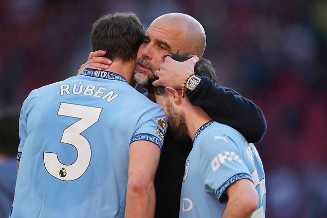 <YONHAP PHOTO-6867> FILE - Manchester City's head coach Pep Guardiola hugs Ruben Dias, left and Bernardo Silva afterthe English Premier League soccer match between Manchester City and Manchester United in Manchester, England, Sunday, April 6, 2025. (AP Photo/Dave Thompson, File) FILE PHOTO/2026-05-22 21:35:24/<저작권자 ⓒ 1980-2026 ㈜연합뉴스. 무단 전재 재배포 금지, AI 학습 및 활용 금지>