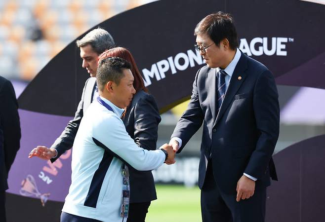 23일 오후 경기 수원종합운동장에서 열린 2025~2026시즌 아시아축구연맹(AFC) 여자 챔피언스리그(AWCL) 결승전 도쿄 베르디 벨레자와 내고향여자축구단의 경기, 최휘영 문화체육부 장관이 우승을 차지한 내고향 리유일 감독과 악수하고 있다. 사진=뉴시스