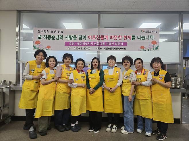 어머니의 뜻을 기리기 위한 무료급식 행사를 준비한 이명선 회원(한가운데)이 자원봉사자들과 기념 사진을 찍고 있다.