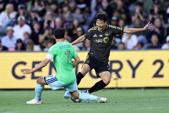 LA FC의 손흥민(오른쪽)이 24일(현지 시각) 미국 LA BMO스타디움에서 열린 시애틀 사운더스와의 MLS(미 프로축구) 홈 경기에서 상대 수비수를 제치고 있다. /AFP 연합뉴스