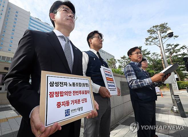 질문에 답하는 동행노조 (수원=연합뉴스) 권준우 기자 = 26일 오전 경기 수원시 수원지법 청사 앞에서 삼성전자 디바이스경험(DX) 부문 직원들이 주축이 된 삼성전자 노동조합 동행(동행노조) 집행부가 삼성전자 노사 임금협상 잠정합의안 찬반 투표 중지 등 가처분 신청서를 제출하기 전 취재진의 질문에 답하고 있다. 2026.5.26 stop@yna.co.kr