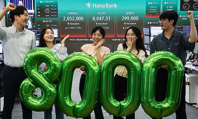 코스피 지수가 종가 기준 최초로 8,000대를 기록한 26일 서울 중구 하나은행 본점 딜링룸에서 직원들이 축하 세레머니를 하고 있다. 뉴스1
