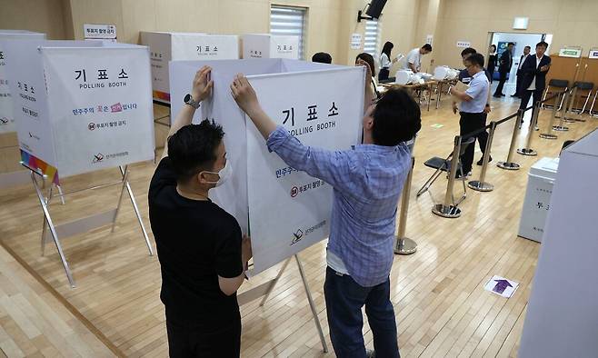 제9회 전국동시지방선거 사전투표일을 하루 앞둔 28일 오후 서울 종로구 종로1,2,3,4가동 주민센터 사전투표소에서 직원들이 기표소를 정리하고 있다. 김혜윤 기자 unique@hani.co.kr