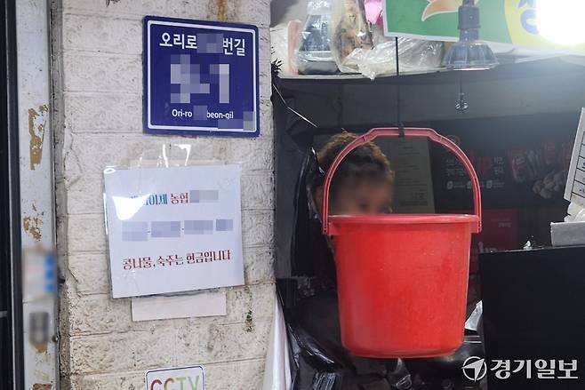 28일 광명시 광명동의 광명전통시장 내 한 점포에 객단가가 낮은 제품의 현금 결제 유도 안내문이 붙여져있다. 한준호기자