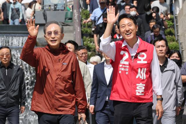 ▲ 국민의힘 오세훈 서울시장 후보가 15일 서울 중구 청계천 모전교 인근에서 시민들을 향해 손을 흔들고 있다. 이날 이원호 집행위원장은 이들에 대한 항의를 하다가 제지당하기도 했다. ⓒ연합뉴스