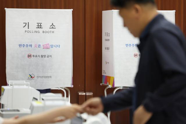 제9회 전국동시지방선거 사전투표 첫날인 29일 서울 서초구의 한 사전투표소에서 유권자가 투표용지를 받고 있다. 연합뉴스