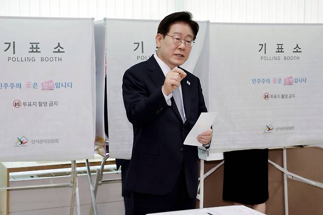 이재명 대통령이 제9회 전국동시지방선거 사전투표 첫날인 29일 서울 종로구 삼청동 주민센터에서 사전 투표 중 기표 도장 관련 문의를 하고 있다./뉴시스