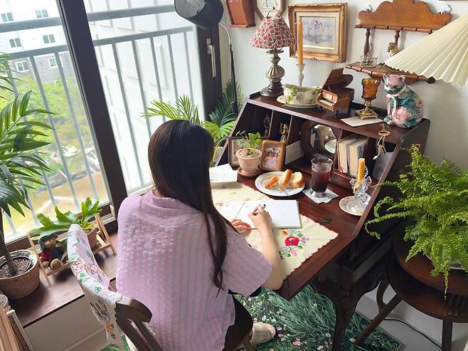 오정원씨가 침실 발코니에서 일기를 쓰고 있는 모습. 오씨는 자신이 좋아하는 소품으로 가득 채운 이 공간을 '아지트'라고 소개했다. 오씨 제공