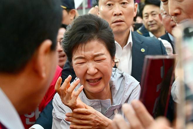 박근혜 전 대통령이 5월27일 경남 진주시 진주중앙시장에서 시민과 악수 후 손이 아픈 듯 인상을 쓰고 있다. ⓒ공동취재