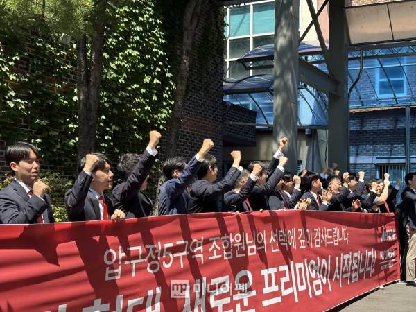 압구정5구역 개표 결과가 나온 이후 현대건설 관계자들이 현수막을 펼치며 환호하고 있다./사진=미디어펜 박소윤 기자