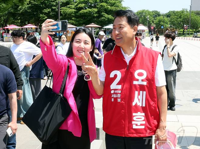 오세훈 국민의힘 서울시장 후보가 30일 오후 서울 영등포구 여의도 한강공원을 찾아 지지자와 셀카를 찍고 있다. 2026.5.30 ⓒ 뉴스1 김진환 기자