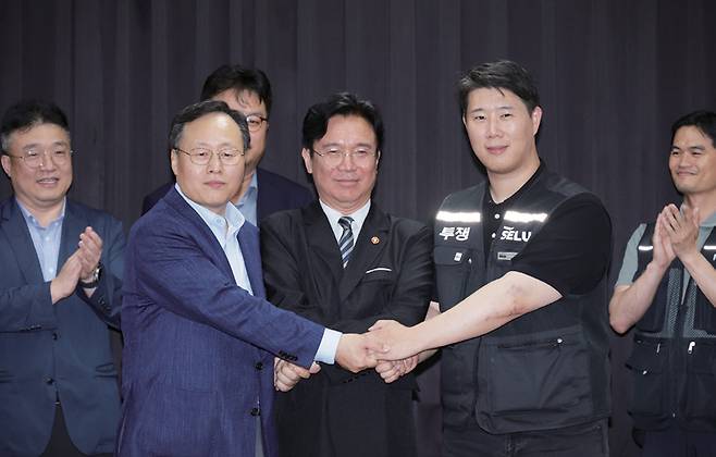 5월20일 경기고용노동청에서 임금 협상을 마친 여명구 삼성전자 DS 피플팀장(왼쪽)과 최승호 삼성그룹 초기업 노조 삼성전자지부 위원장이 김영훈 고용노동부 장관(가운데)과 손을 맞잡고 있다. ⓒ연합뉴스