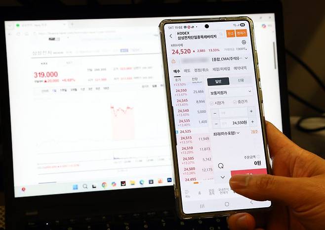 삼성전자와 SK하이닉스 단일종목 레버리지 상장지수펀드(ETF)가 출시된 지난 27일 서울의 한 사무실에서 개인 투자자가 모바일트레이딩시스템(MTS)을 살펴보고 있다. 뉴스1 제공