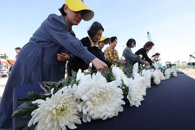 지난달 16일 오후 전남 목포신항에서 세월호 참사 12주기 목포기억식에 참여한 추모객들이 헌화하고 있다. 사진 뉴시스