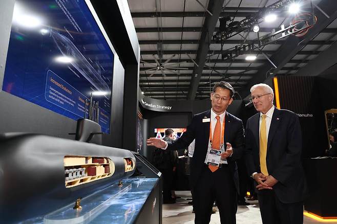 캐나다 오타와에서 열린 ‘CANSEC 2026’ 전시회 내 한화오션 부스에서 한화오션 특수선해외사업단장 정승균 부사장(왼쪽)이 빅터 피델리 온타리오주 경제개발부 장관에게 최신예 잠수함인 KSS-III 모델을 소개하며 그 우수성을 설명하고 있다. 한화오션 제공