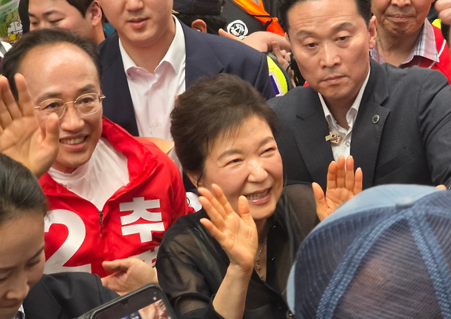 박근혜 전 대통령과 추경호 국민의힘 대구시장 후보(왼쪽)가 31일 대구 중구 서문시장을 찾아 시민들에게 손을 흔들고 있다. 2026. 5. 31. 대구 민경석 기자