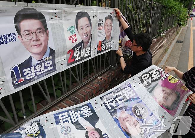 4일 오전 서울 종로구 예술가의 집 담장에서 서울시 선거관리위원회 관계자들이 제9회 전국동시지방선거 벽보를 철거하고 있다. ⓒ 뉴스1 오대일 기자