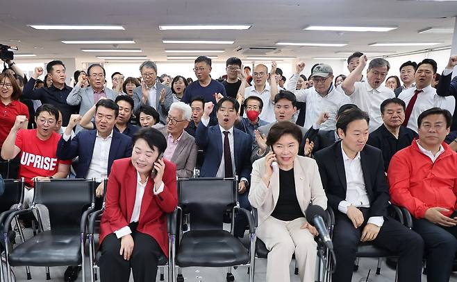 4일 서울 종로구 대왕빌딩에 마련된 국민의힘 오세훈 서울시장 후보 선거사무소에서 선대위 관계자와 오 후보 지지자들이 개표 방송을 시청하며 기뻐하고 있다. 연합뉴스