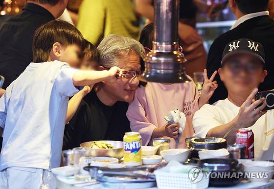 젠슨 황 엔비디아 최고경영자(CEO)가 5일 서울 마포구 홍대 인근 삼겹살 음식점 '형님 저요'에서 최태원 SK그룹 회장, 구광모 LG그룹 회장, 이해진 네이버 의장과 '삼소(삼겹살·소주) 회동'을 하며 한 가족과 기념촬영을 하고 있다. 〈사진=연합뉴스〉