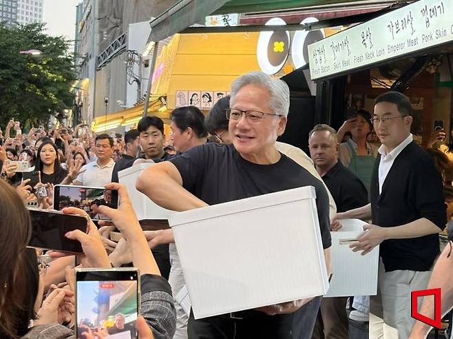 젠슨 황 엔비디아 최고경영자(CEO)가 시민들에게 간식을 나눠주고 있다. 장보경 기자