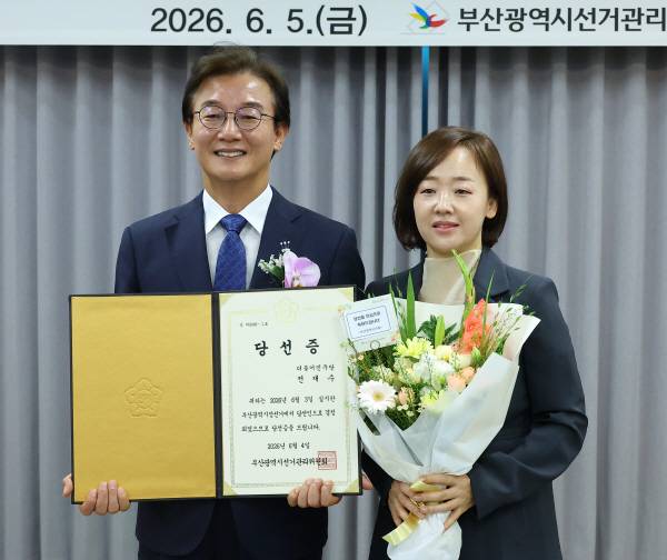 더불어민주당 전재수 부산시장 당선인이 5일 부산 연제구 부산시선관위에서 열린 당선증 교부식에서 배우자 최혜진 씨와 함께 기념촬영을 하고 있다. 연합뉴스