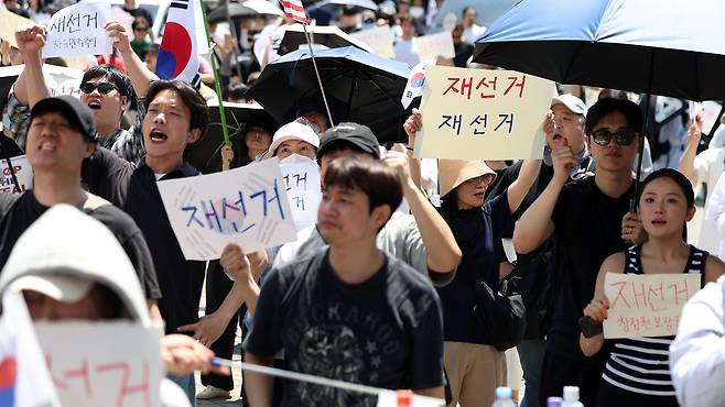투표용지 부족 사태에 항의하며 개표소 봉쇄 시위를 이어가는 시민들이 6일 서울 송파구 올림픽공원 핸드볼경기장에 설치된 개표소 앞에서 재선거를 요구하고 있다. /뉴시스