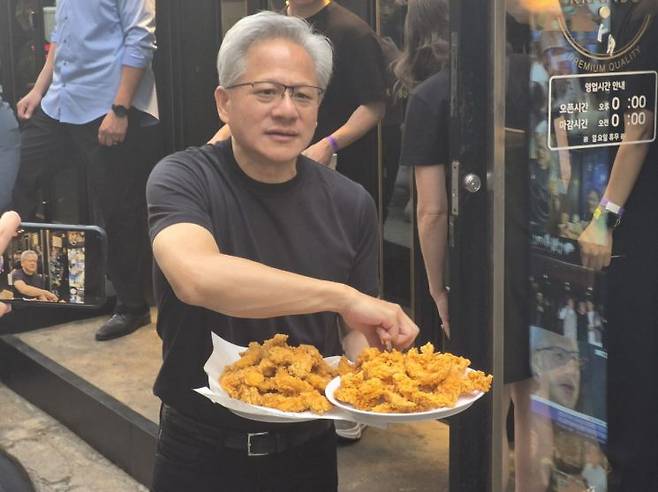 젠슨 황 엔비디아 최고경영자(CEO)이 7일 서울 강남구 깐부치킨 삼성점 앞에서 시민들에게 치킨을 나눠주고 있다. 김진영 기자.