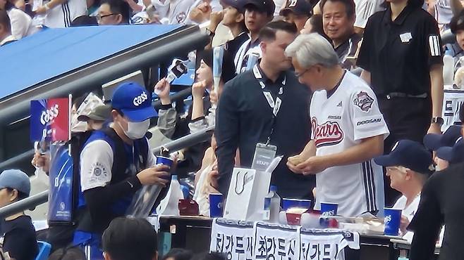 젠슨 황(오른쪽) 엔비디아 CEO가 7일 잠실구장에서 열린 2026 KBO리그 키움과 두산전에서 맥주 판매원에게 5만 원짜리 지폐를 건네고 있다. 김형준 기자