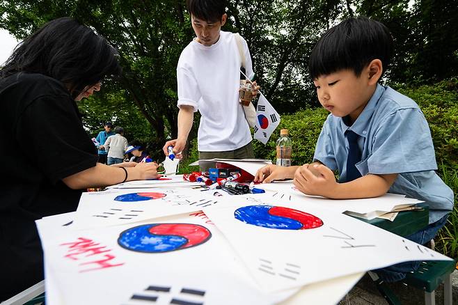 7일 개표소로 사용된 서울 송파구 올림픽공원 핸드볼경기장 주변에서 시위 참가자와 어린이가 태극기를 그리고 있다. 김재훈 기자