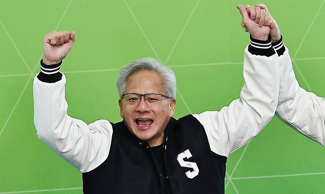 젠슨 황 엔비디아 최고경영자(CEO)가 8일 서울대학교 해동첨단공학관에서 열린 \'\'빌드어클로(Build-a-Claw)\'\' 행사장에서 유홍림 서울대 총장(오른쪽)으로부터 학교 점퍼를 선물받은 뒤 환호하고 있다. 연합뉴스