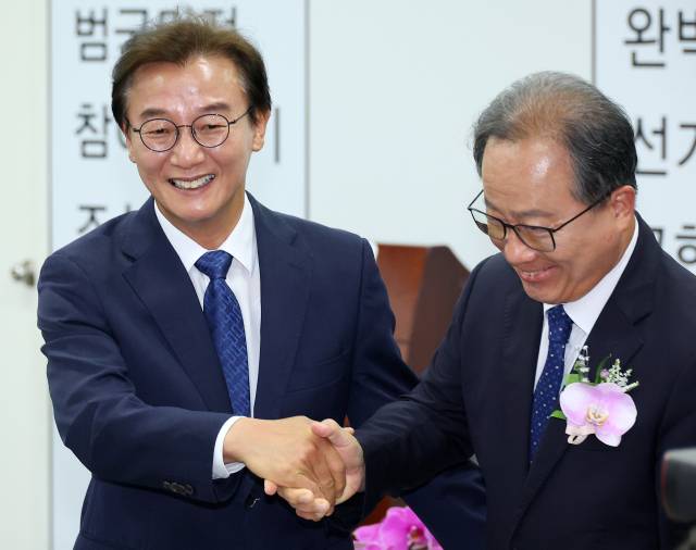 전재수 부산시장 당선인과 김석준 부산시교육감 당선인이 5일 부산 연제구 부산시선관위에서 열린 당선증 교부식에서 만나 악수하고 있다. 연합뉴스