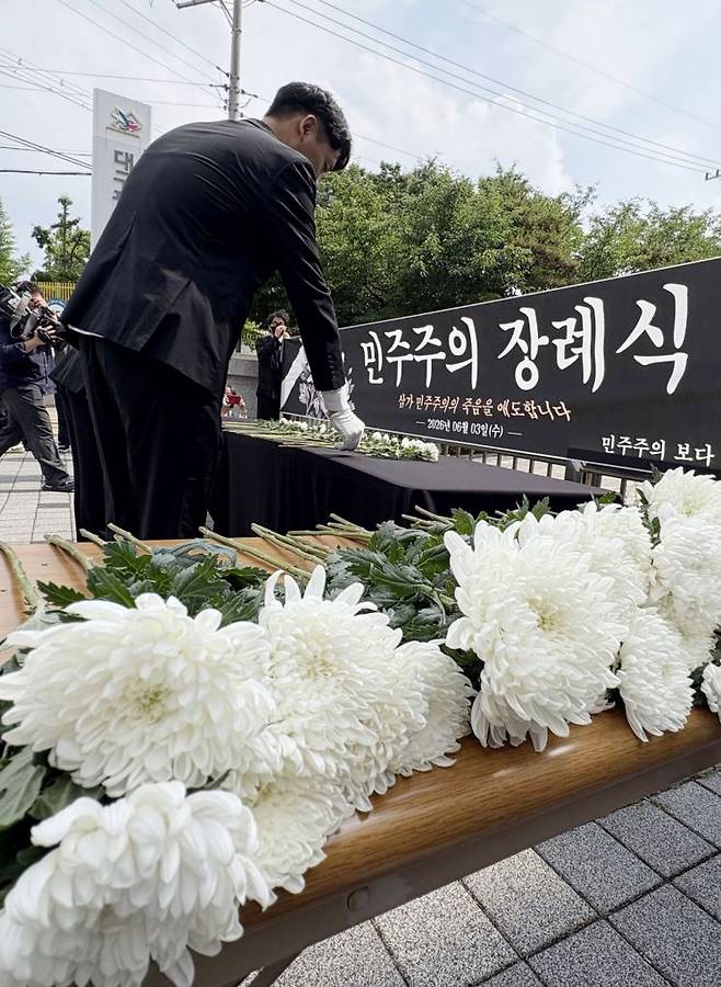 6·3 지방선거에서 벌어진 투표용지 부족 사태 등과 관련해 지난 8일 오후 대구시 선관위 앞에서 지역 기초의원들이 민주주의 장례식 퍼포먼스를 진행하고 있다. 연합뉴스