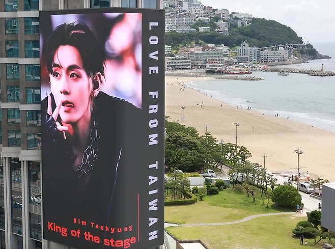 BTS의 공연을 앞두고 9일 부산 해운대해수욕장 앞 그랜드조선 호텔 외벽에 설치된 초대형 미디어 전광판에 방탄소년단(BTS) 뷔 사진이 송출되고 있다. 2026.6.9 / 사진=연합뉴스
