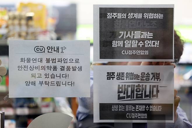 편의점 CU 운영사 BGF리테일과 화물연대 간 갈등이 격화되며 물류 배송에 차질이 빚어진 가운데 27일 서울 시내의 한 CU 편의점에서 CU가맹점주연합회 회원 점주가 항의 피켓을 붙이고 있다. /뉴시스