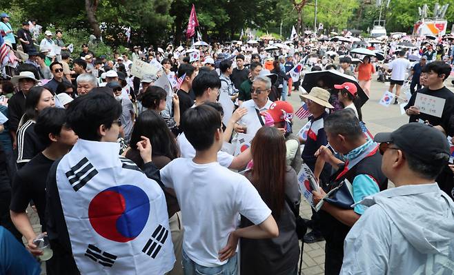 제9회 전국동시지방선거 투표용지 부족 사태에 항의하며 개표소 봉쇄 시위를 이어가고 있는 10일 서울 송파구 올림픽공원 핸드볼경기장에 설치된 개표소 앞에서 시민과 경찰이 대치상황이 벌어질뻔 하자 청년들이 이를 제지하고 있다./사진=뉴시스.