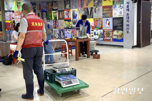 12일 오전 수원시 팔달구 수원역전시장 건물 지하 1층에서 진행한 상거래용 계량기 정기검사 현장. 한 상인이 수레에 전자저울을 싣고 검사를 받기 위해 차례를 기다리고 있다. 2026.6.12 /유혜연기자 pi@kyeongin.com